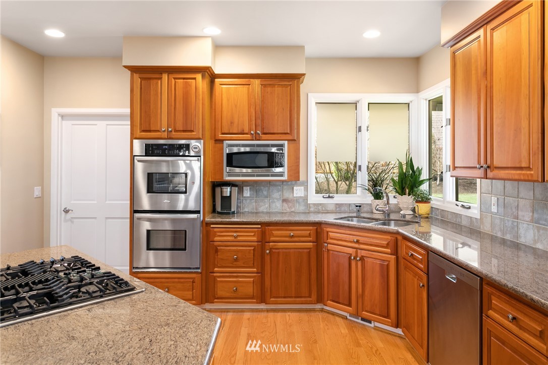21731 35th Avenue Southeast Bothell, WA 98021 - Photo 12 of 36 a kitchen with stainless steel appliances a sink stove and cabinets