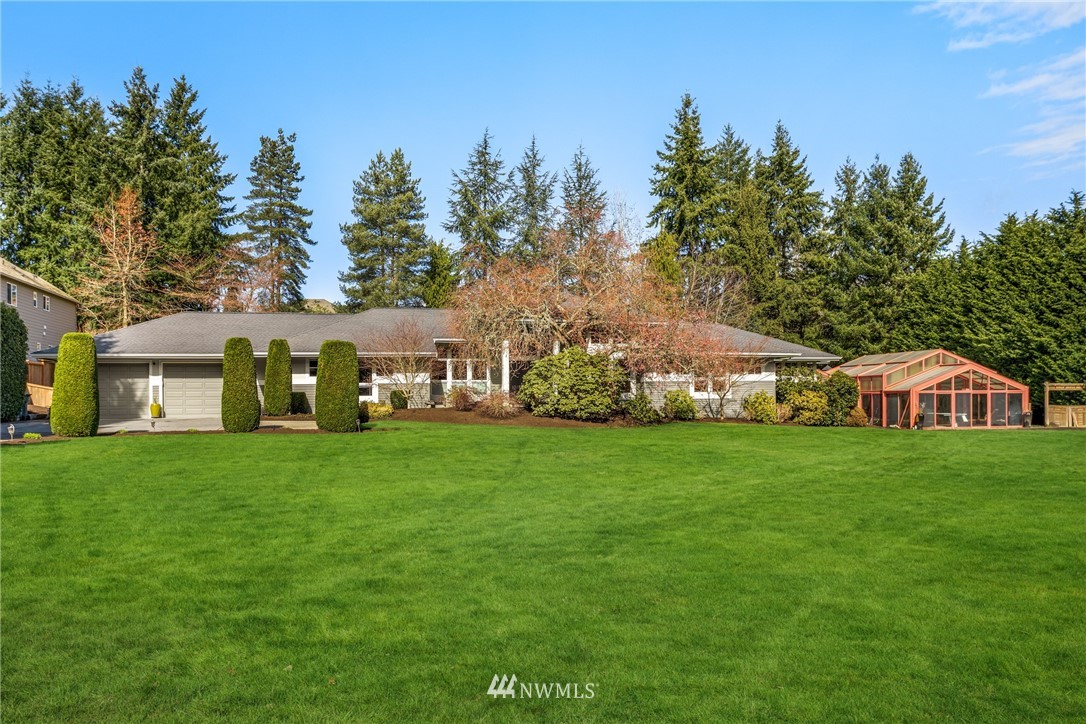 21731 35th Avenue Southeast Bothell, WA 98021 - Photo 4 of 36 a front view of a house with a yard table and trees