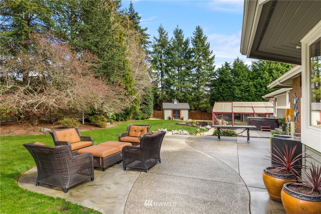 21731 35th Avenue Southeast Bothell, WA 98021 - Photo 33 of 36 a view of a patio with table and chairs potted plants and a palm tree