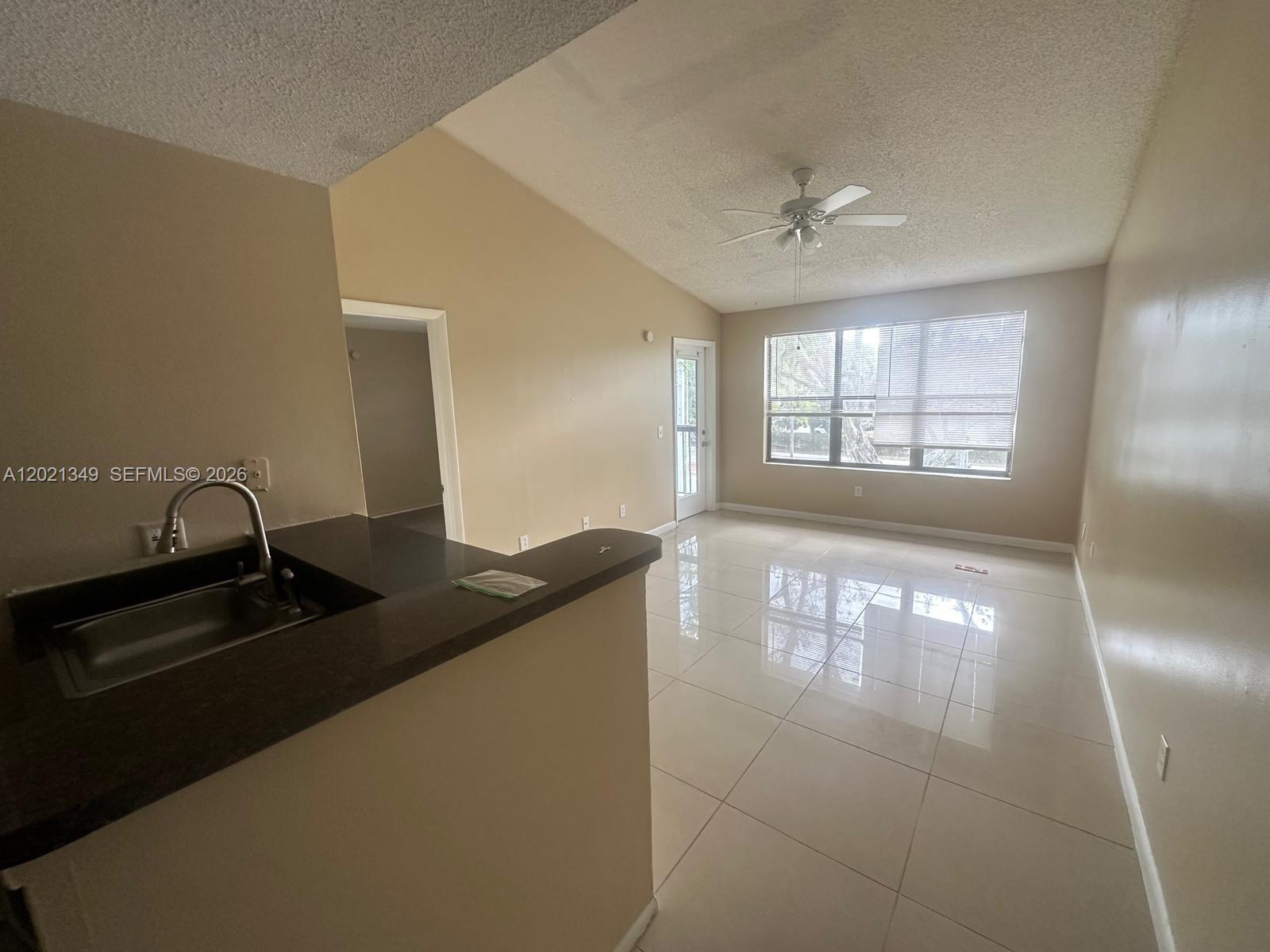 4481 West McNab Road, Unit 37 Pompano Beach, FL 33069 - Photo 19 of 20 a kitchen with granite countertop a sink stainless steel appliances and a counter top space