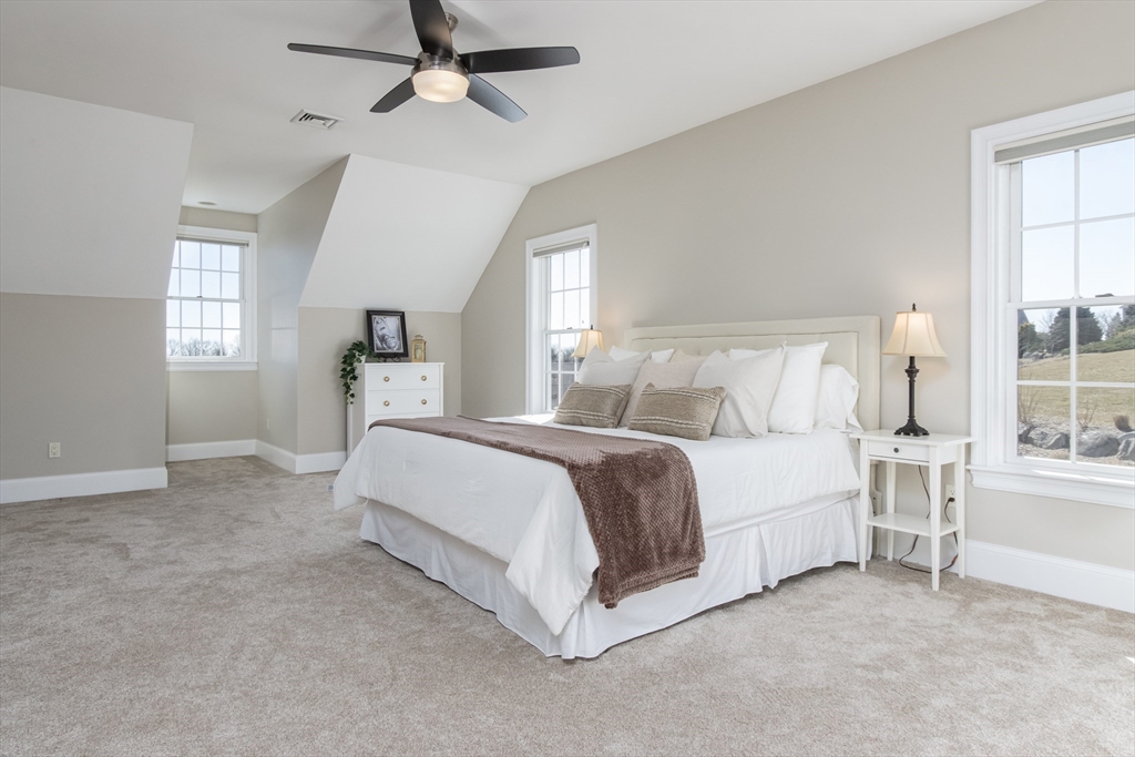 63 Skyfields Drive Groton, MA 01450 - Photo 19 of 40 a spacious bedroom with a bed couch and windows