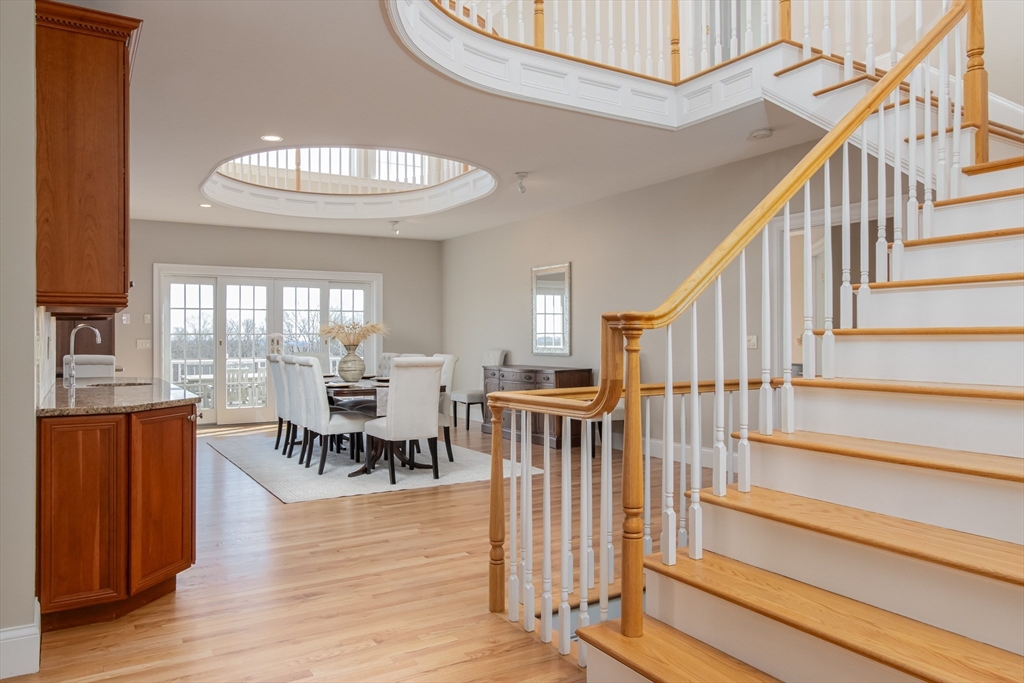 63 Skyfields Drive Groton, MA 01450 - Photo 2 of 40 a view of dining room and livingroom with furniture wooden floor clock and a chandelier