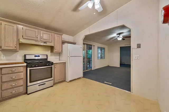 a kitchen with refrigerator and cabinets