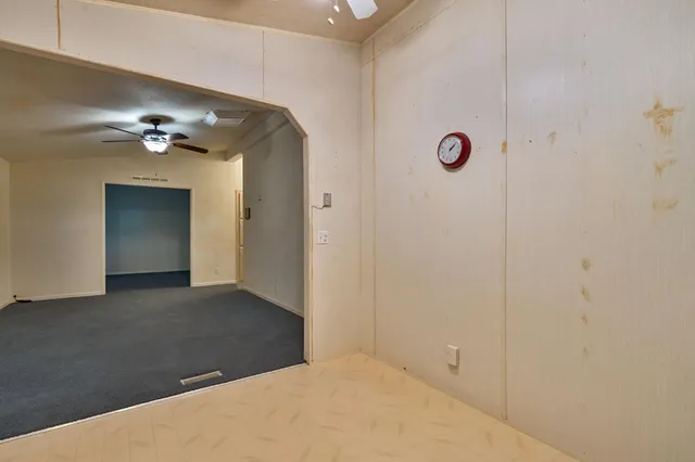 a view of a hallway with a chandelier fan
