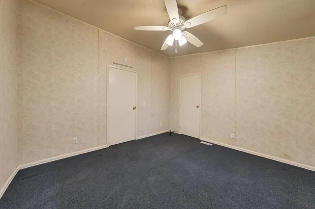 an empty room with a chandelier fan