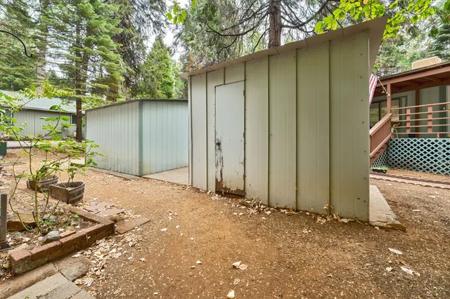 a backyard of a house with a tree and fence