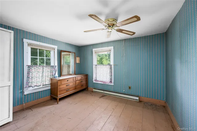 an empty room with window and ceiling fan