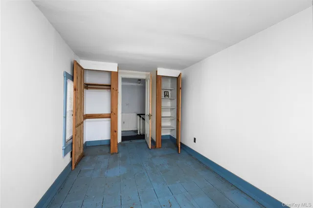 a view of empty room with wooden floor and closet