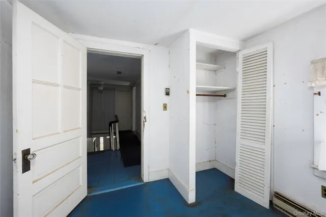 a view of a hallway with wooden floor and closet