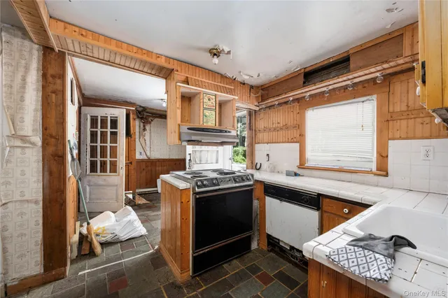 a kitchen with granite countertop a sink stove and cabinets