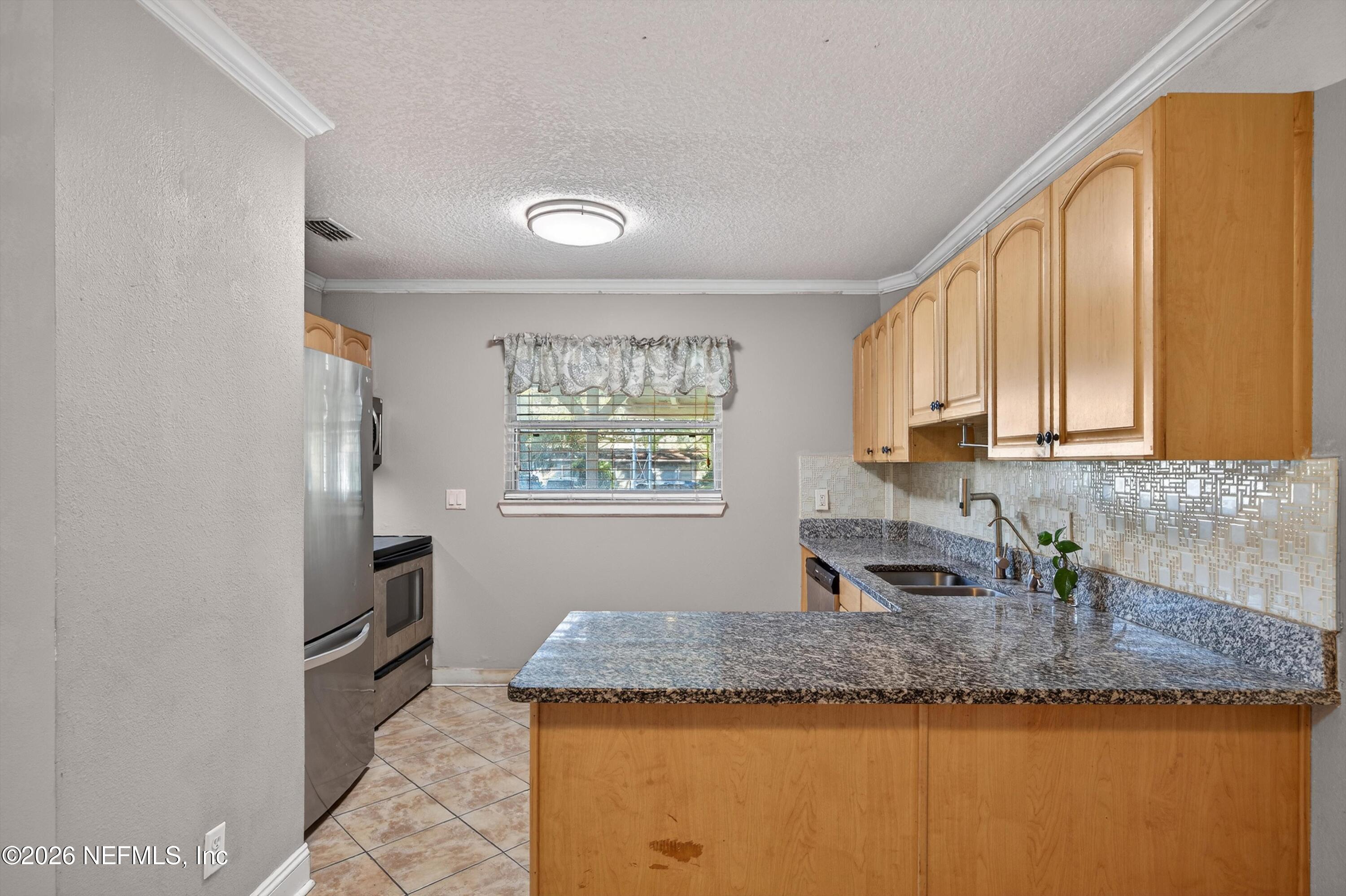 5134 Damascus Road South Jacksonville, FL 32207 - Photo 15 of 41 a kitchen with granite countertop kitchen island stainless steel appliances a sink stove and cabinets