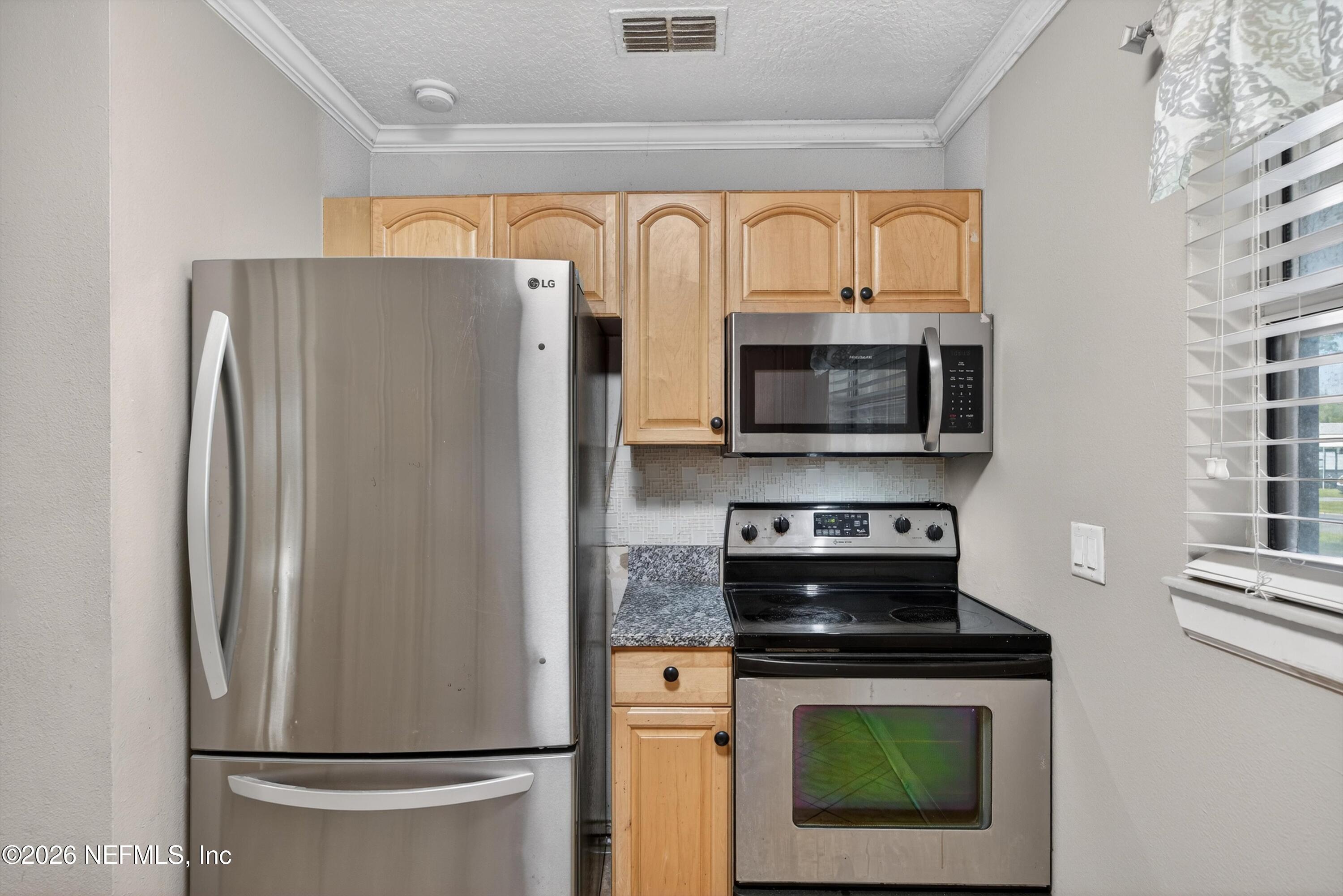 5134 Damascus Road South Jacksonville, FL 32207 - Photo 17 of 41 a kitchen with stainless steel appliances a refrigerator stove and microwave