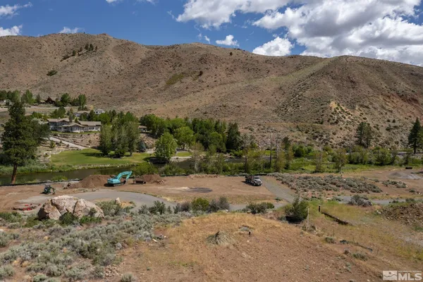 a view of a dirt road with mountains in the background