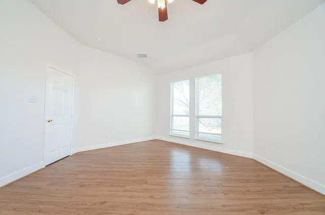 wooden floor in an empty room with a window