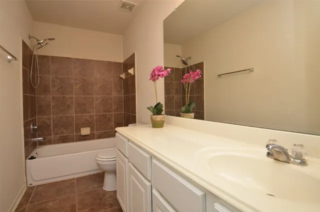 a bathroom with a sink vanity granite toilet tub and shower