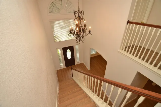 a view of a hallway with wooden floor and staircase