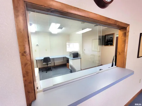 a view of a room with a hallway and wooden floor