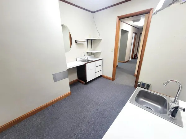 a view of an empty room with wooden floor and cabinet