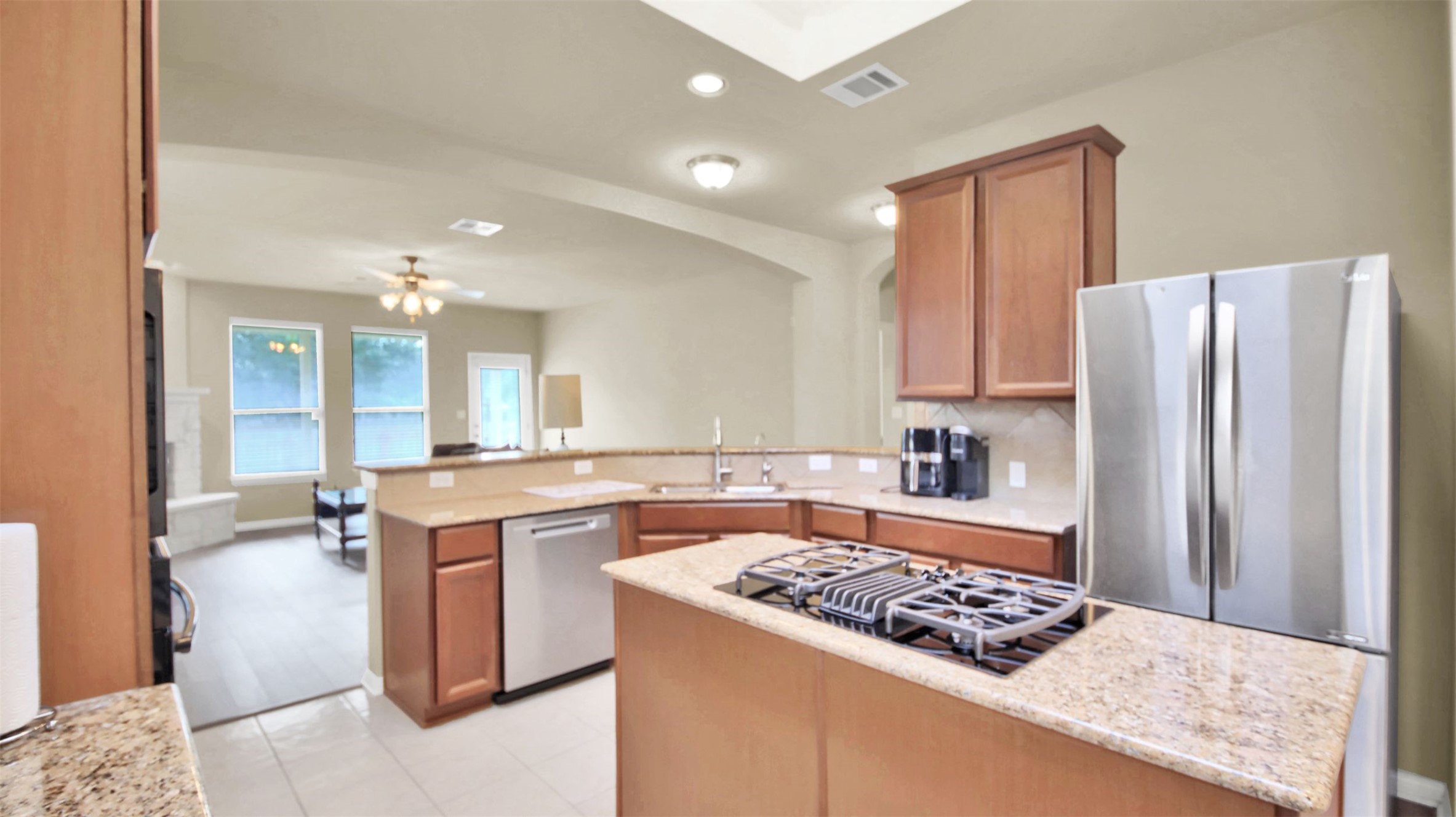 2979 Freemont Street Round Rock, TX 78681 - Photo 15 of 40 Kitchen featuring stainless steel appliances, wood finish cabinets, a center island, recessed lighting, and backsplash