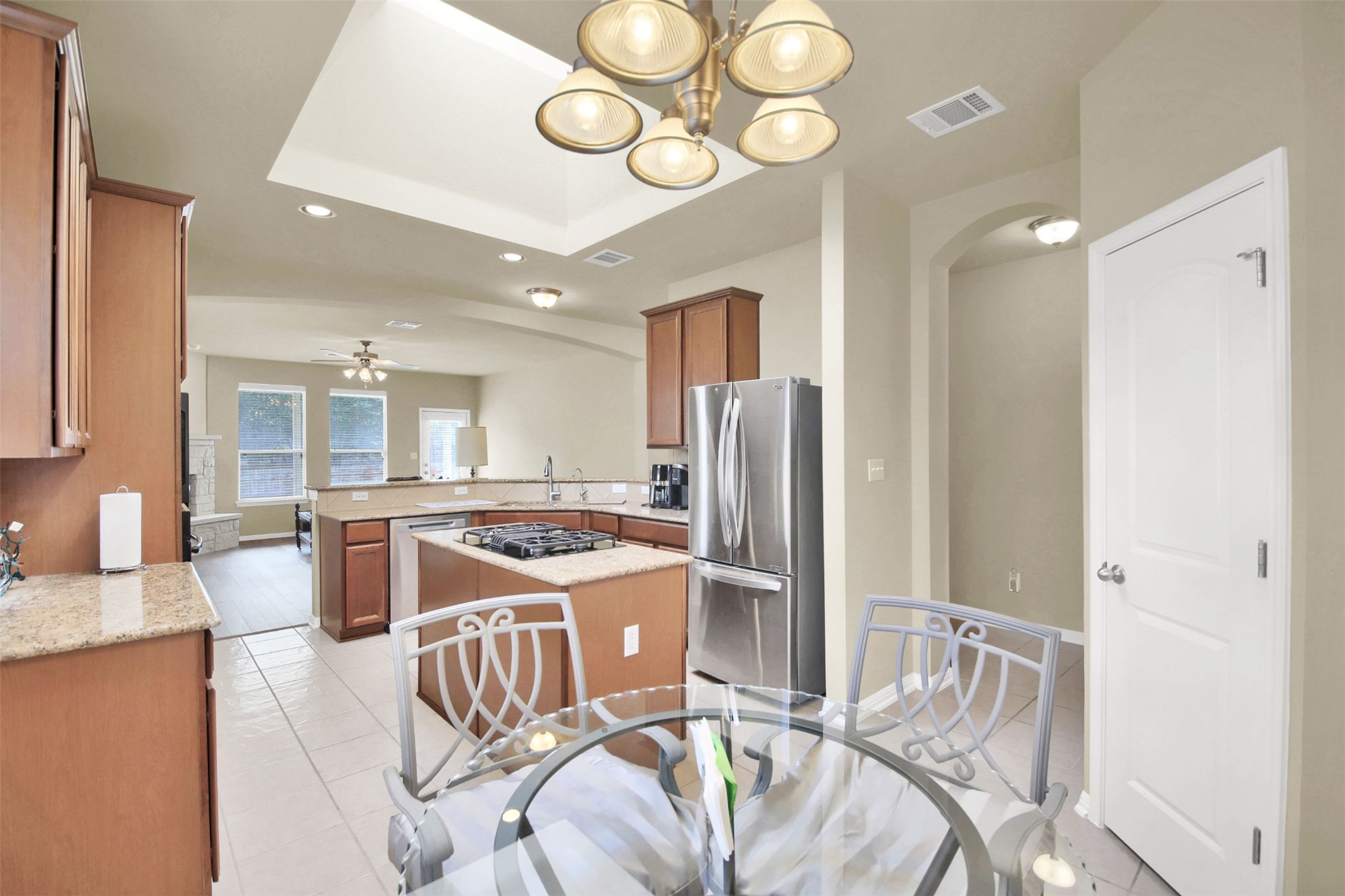 2979 Freemont Street Round Rock, TX 78681 - Photo 19 of 40 Kitchen with stainless steel appliances, wood finish cabinets, arched walkways, and light stone counters