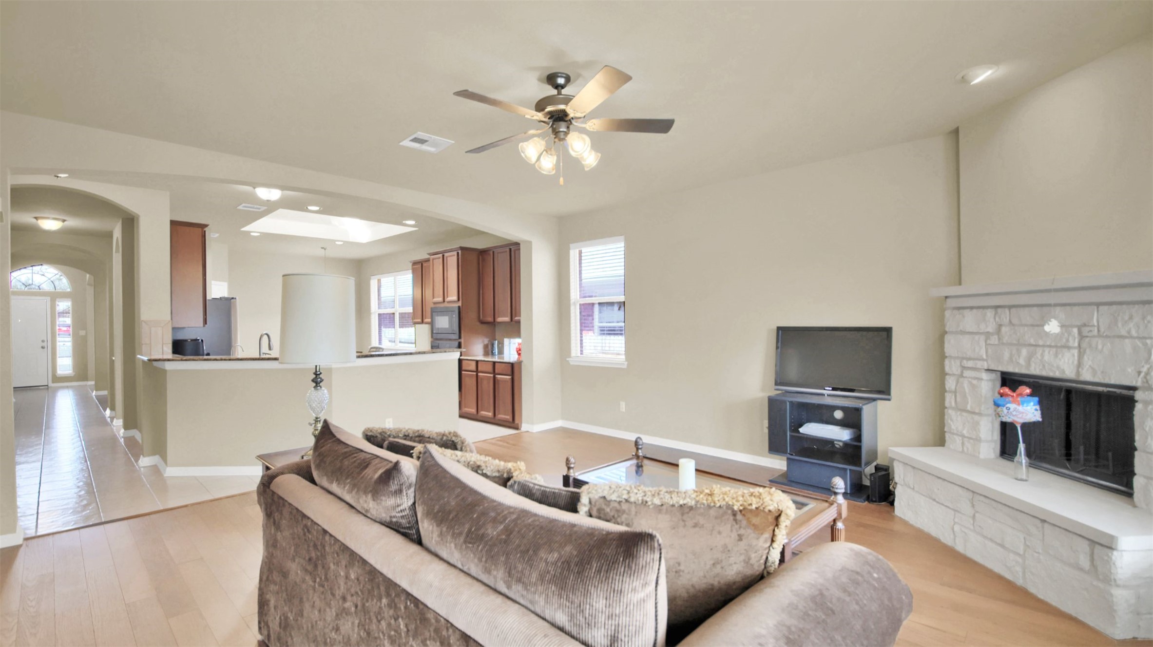 2979 Freemont Street Round Rock, TX 78681 - Photo 22 of 40 Living area with a fireplace, light wood finished floors, ceiling fan, arched walkways, and recessed lighting