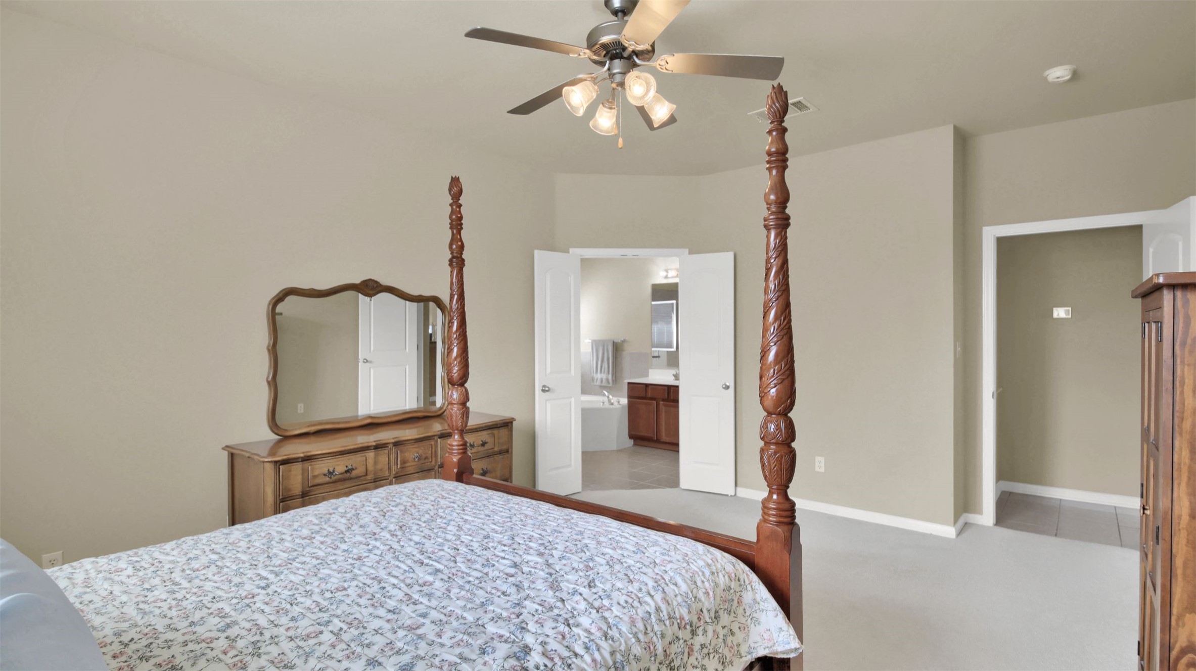2979 Freemont Street Round Rock, TX 78681 - Photo 25 of 40 Primary Bedroom with light colored carpet, ceiling fan, and ensuite bath