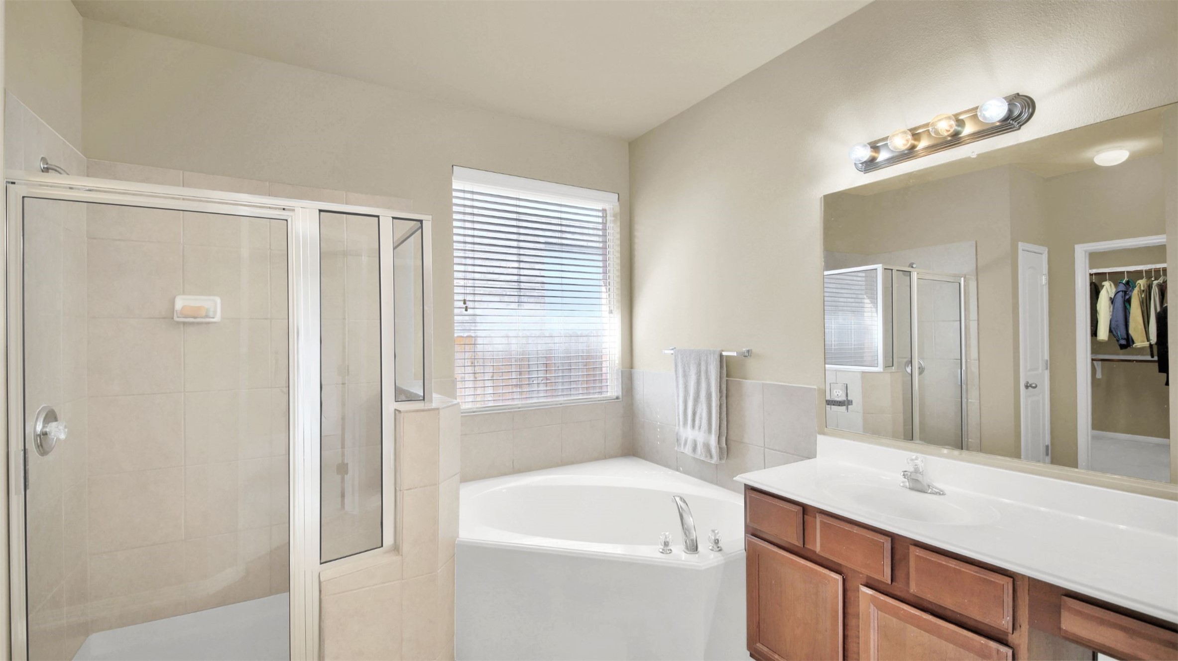 2979 Freemont Street Round Rock, TX 78681 - Photo 27 of 40 Primary bathroom with a shower stall, vanity, a garden tub, and a spacious closet