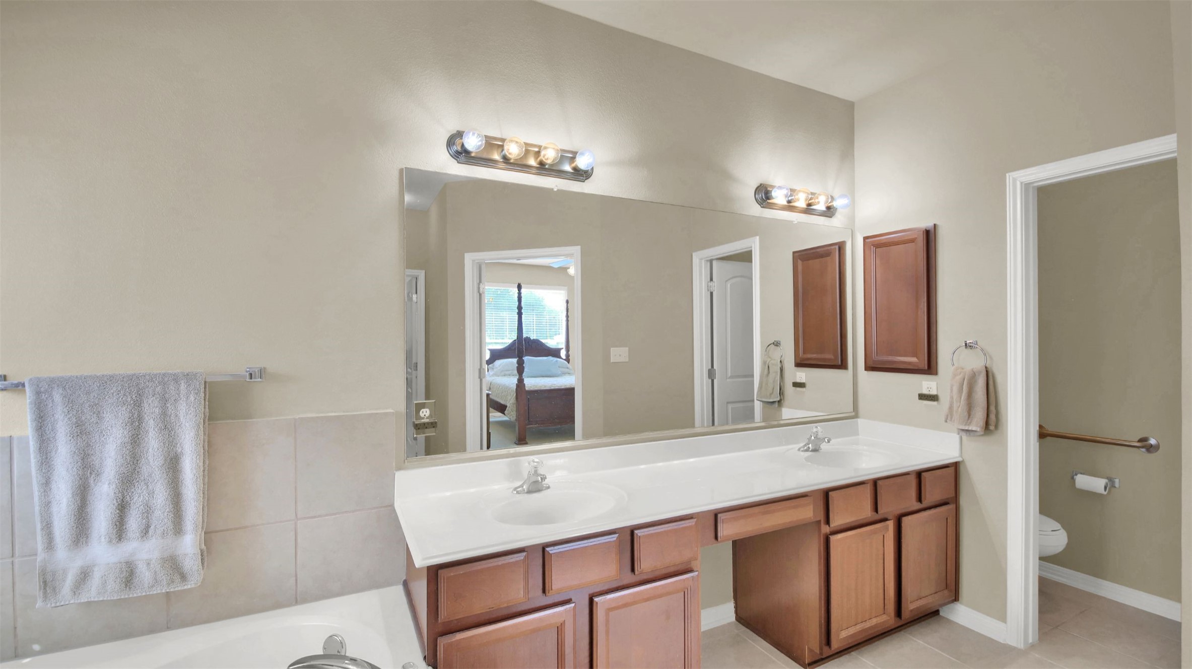 2979 Freemont Street Round Rock, TX 78681 - Photo 28 of 40 Primary bathroom with double vanity, a garden tub, and light tile patterned floors