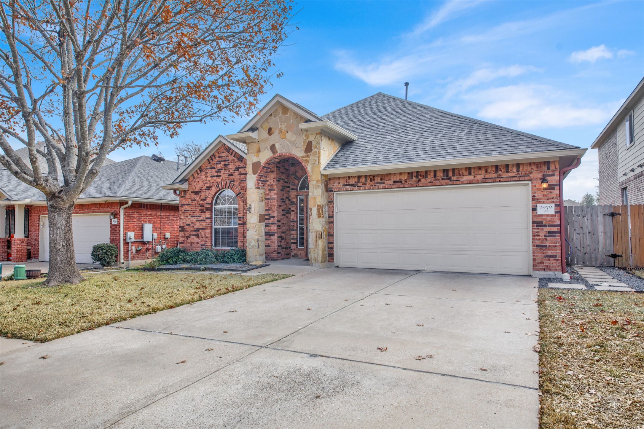 2979 Freemont Street Round Rock, TX 78681 - Photo 3 of 40 View of front of house featuring an attached garage, brick siding, concrete driveway, and roof with shingles