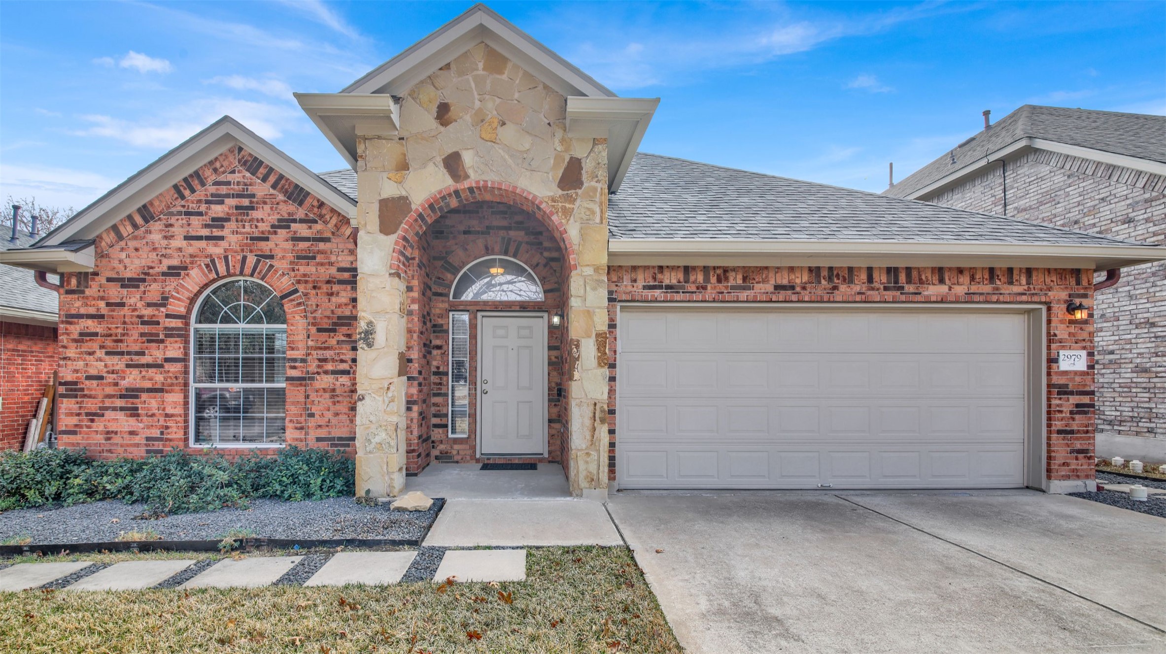 2979 Freemont Street Round Rock, TX 78681 - Photo 4 of 40 View of front of home featuring brick siding, driveway, an attached garage, and stone siding
