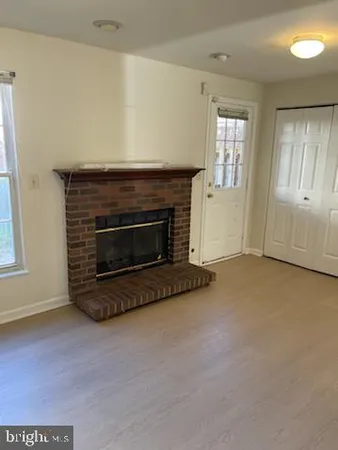 an empty room with windows and fireplace