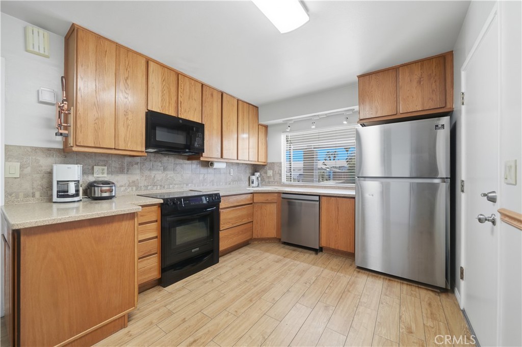 26500 New Bedford Road Menifee, CA 92586 - Photo 11 of 47 a kitchen with a refrigerator sink and wooden cabinets