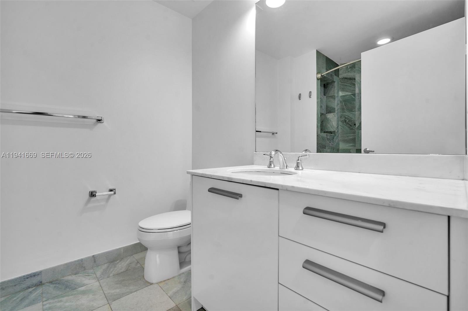 1050 Brickell Avenue, Unit 2418 Miami, FL 33131 - Photo 16 of 25 a bathroom with a sink toilet and a mirror