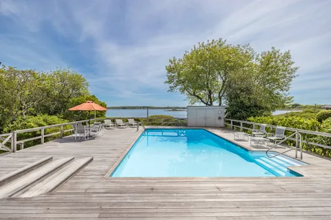 a view of a swimming pool with a patio and a yard