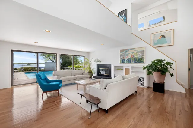 a living room with furniture a fireplace and a floor to ceiling window