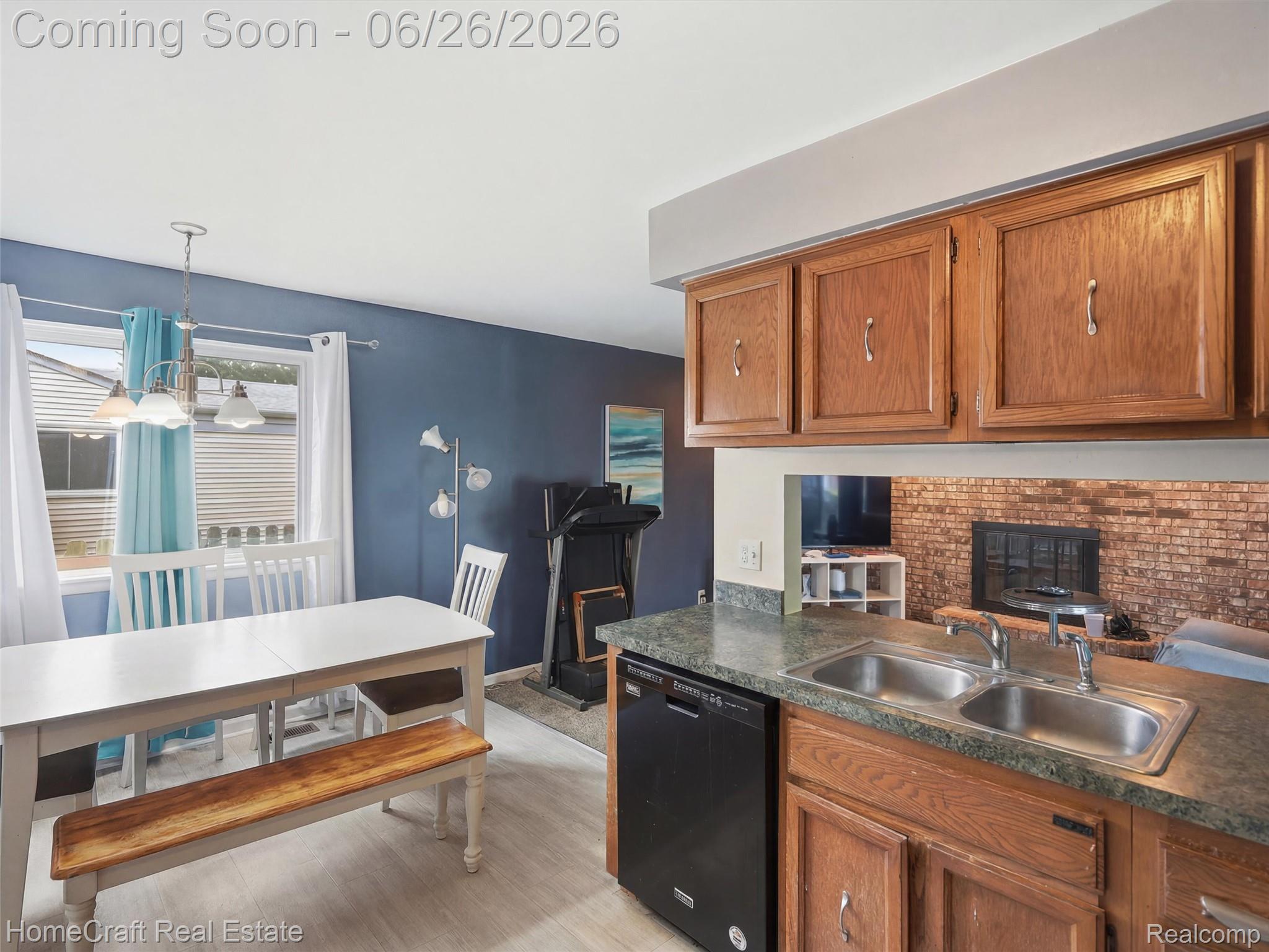 41462 Simcoe Drive Canton, MI 48188 - Photo 4 of 10 Kitchen area featuring wood-finish cabinetry, a dual-basin stainless steel sink, and a black built-in dishwasher