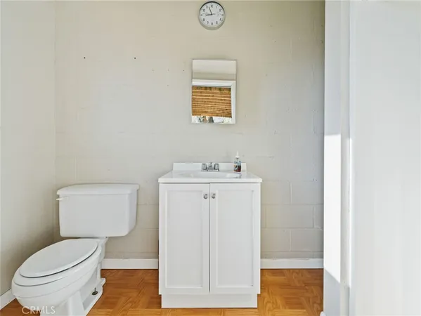 a bathroom with a toilet a sink and mirror