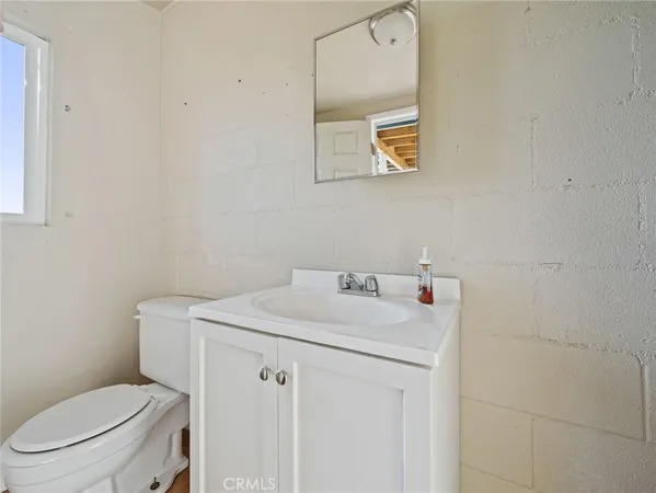 a bathroom with a toilet sink vanity and mirror