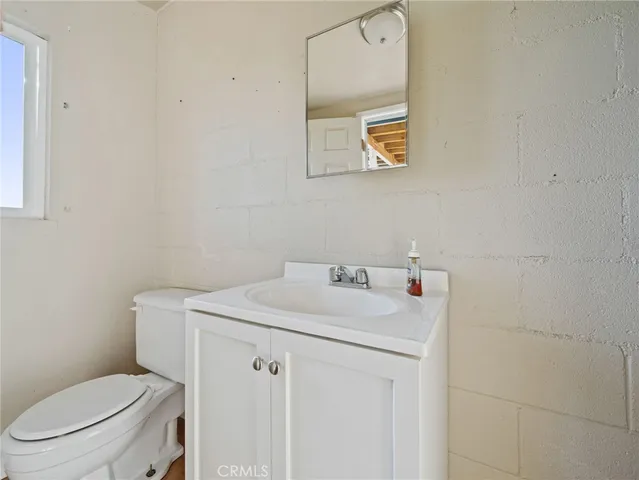 a bathroom with a toilet sink vanity and mirror