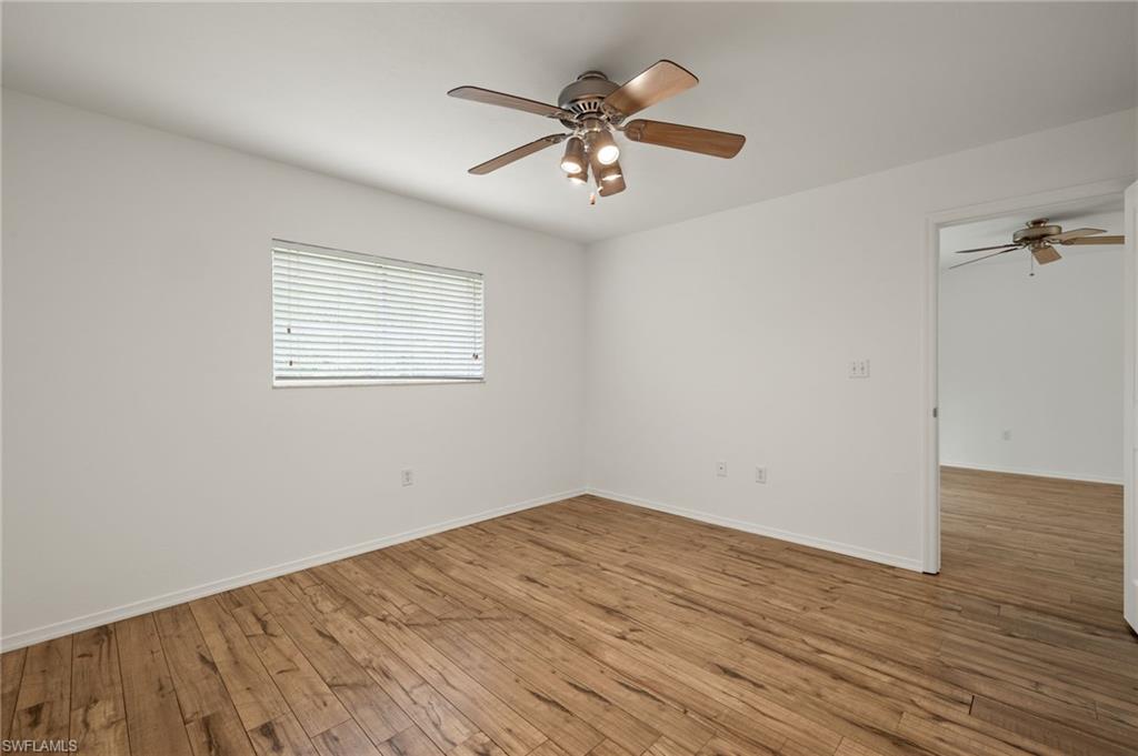 136 Cypress Way East, Unit 507 Naples, FL 34110 - Photo 12 of 21 an empty room with wooden floor fan and windows