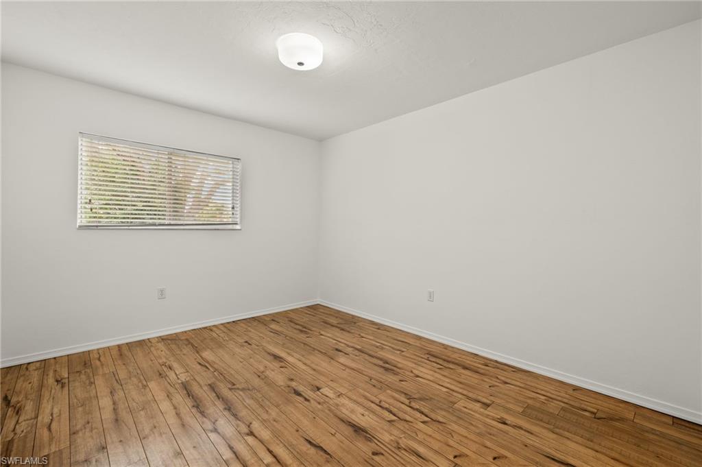 136 Cypress Way East, Unit 507 Naples, FL 34110 - Photo 15 of 21 an empty room with wooden floor and windows
