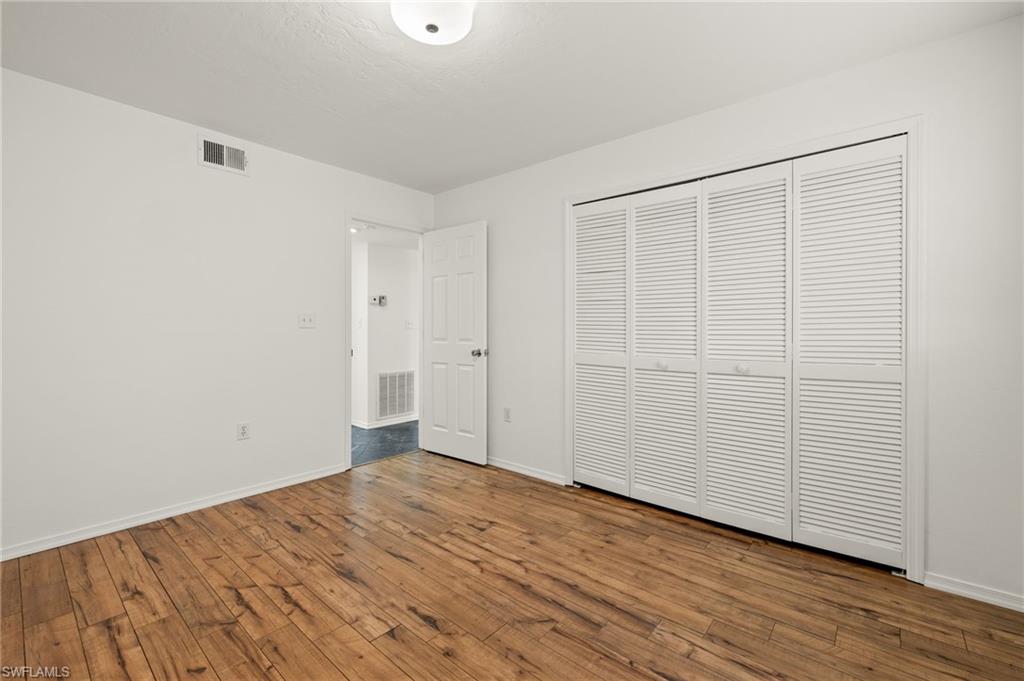 136 Cypress Way East, Unit 507 Naples, FL 34110 - Photo 16 of 21 wooden floor in an empty room