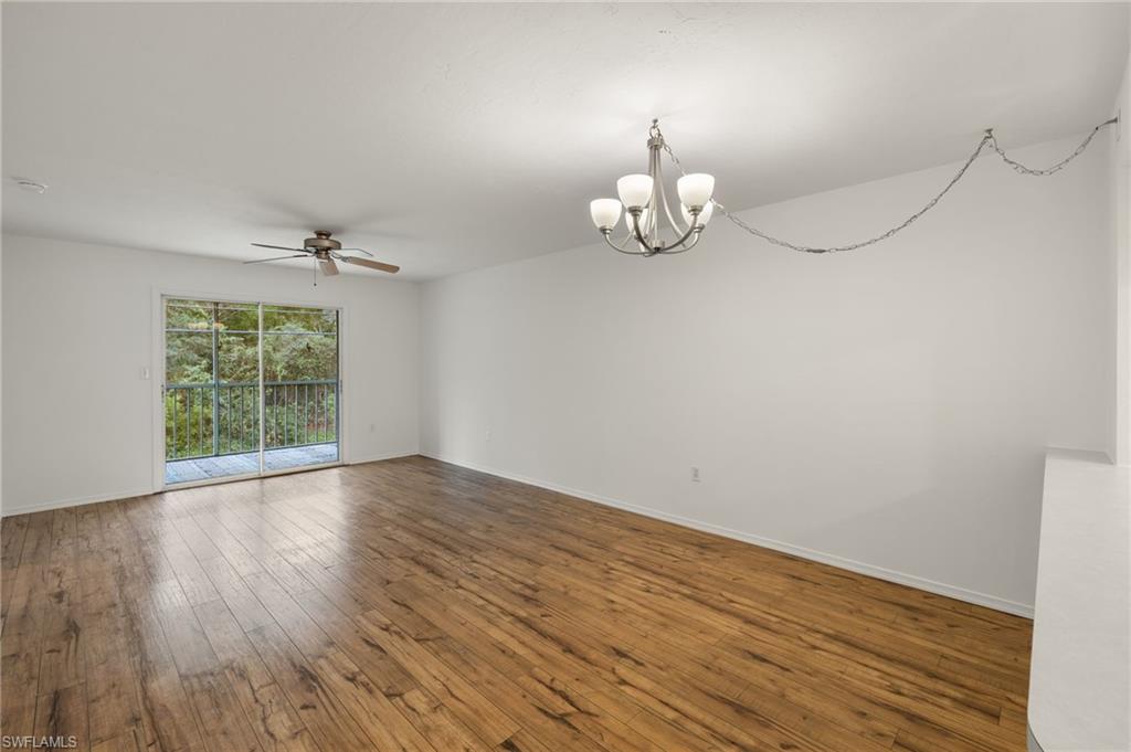 136 Cypress Way East, Unit 507 Naples, FL 34110 - Photo 3 of 21 a view of an empty room with wooden floor and a window