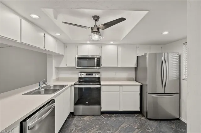 a kitchen with stainless steel appliances a refrigerator sink and microwave