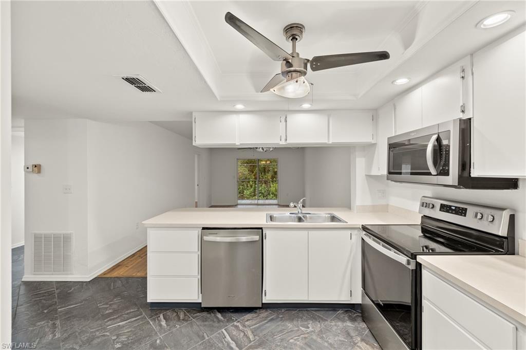 136 Cypress Way East, Unit 507 Naples, FL 34110 - Photo 8 of 21 a kitchen that has a sink and a stove
