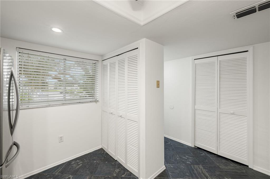 136 Cypress Way East, Unit 507 Naples, FL 34110 - Photo 9 of 21 a view of an empty room with wooden floor and a window