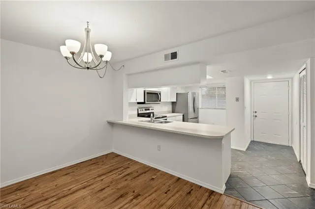 a kitchen with kitchen island stainless steel appliances a sink and cabinets