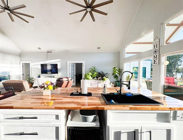 a view of house with a big yard and large trees