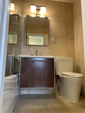 a bathroom with a sink a toilet and mirror