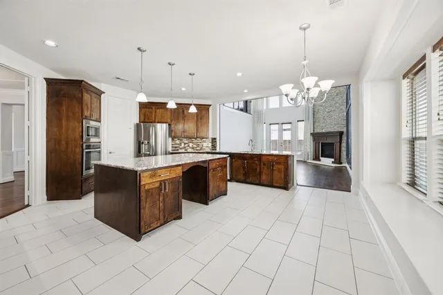 a large kitchen with stainless steel appliances granite countertop a refrigerator and a sink